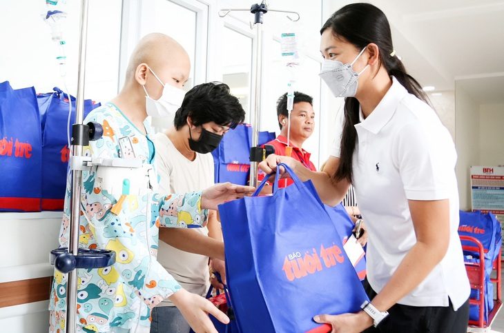 Kình ngư Ánh Viên (phải) trao quà cho các bệnh nhi tại Bệnh viện Truyền máu - Huyết học TP.HCM - Ảnh: PHƯƠNG QUYÊN